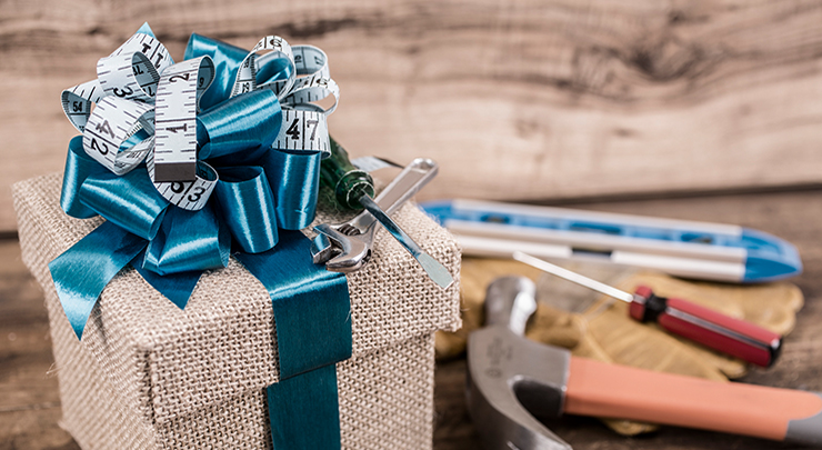 Weihnachtsgeschenk im Vordergrund, Hintergrund: Schraubenzieher und Hammer