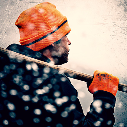 Mann trägt eine orange Mütze und orange Arbeitshandschuhe - Gebol